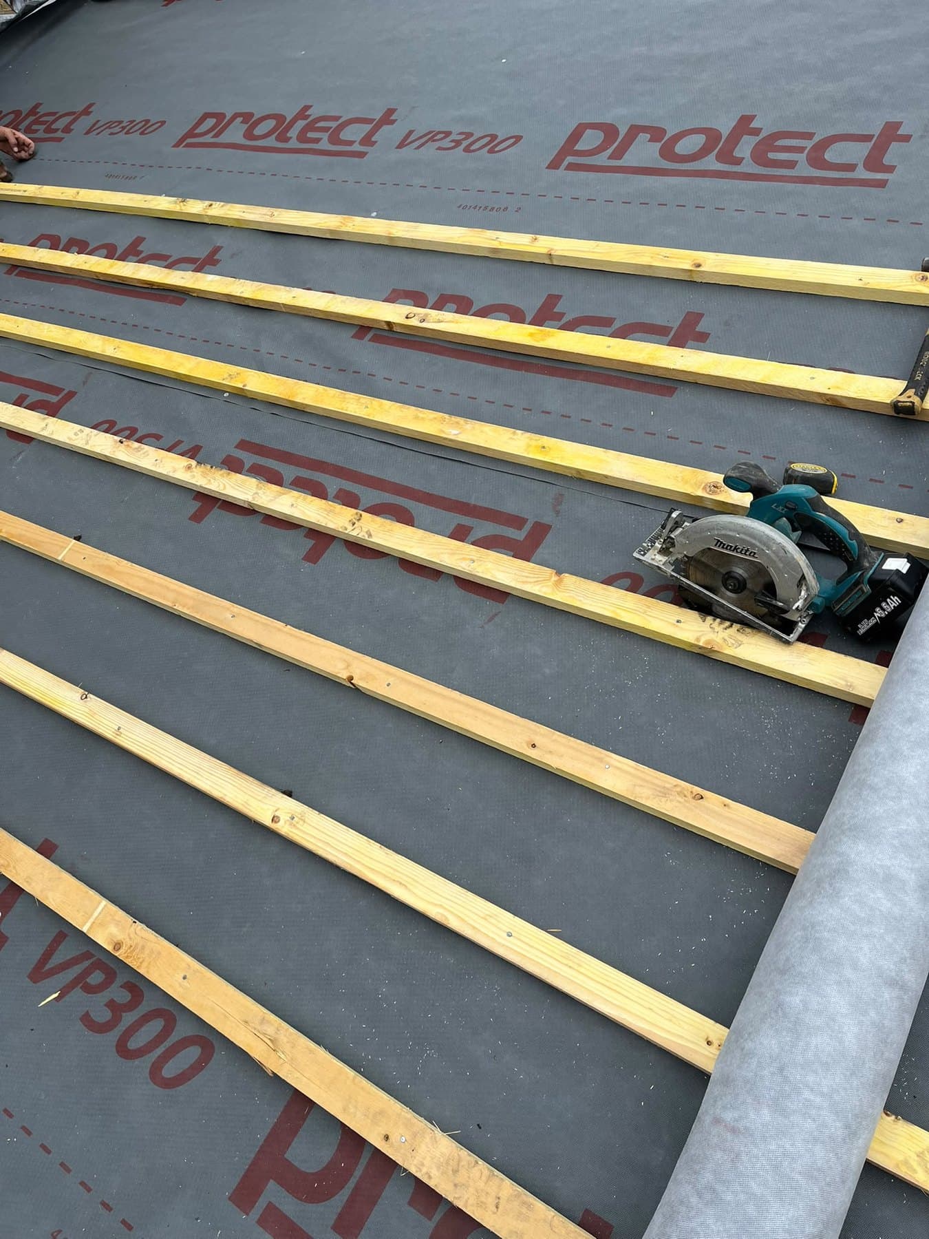 Circular saw resting on new battens over breathable membrane