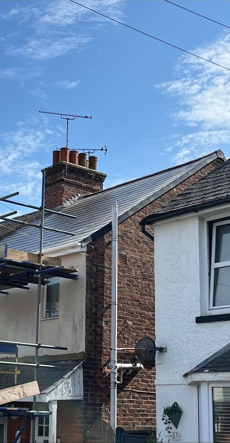 Brick chimney and aerial above a rendered house