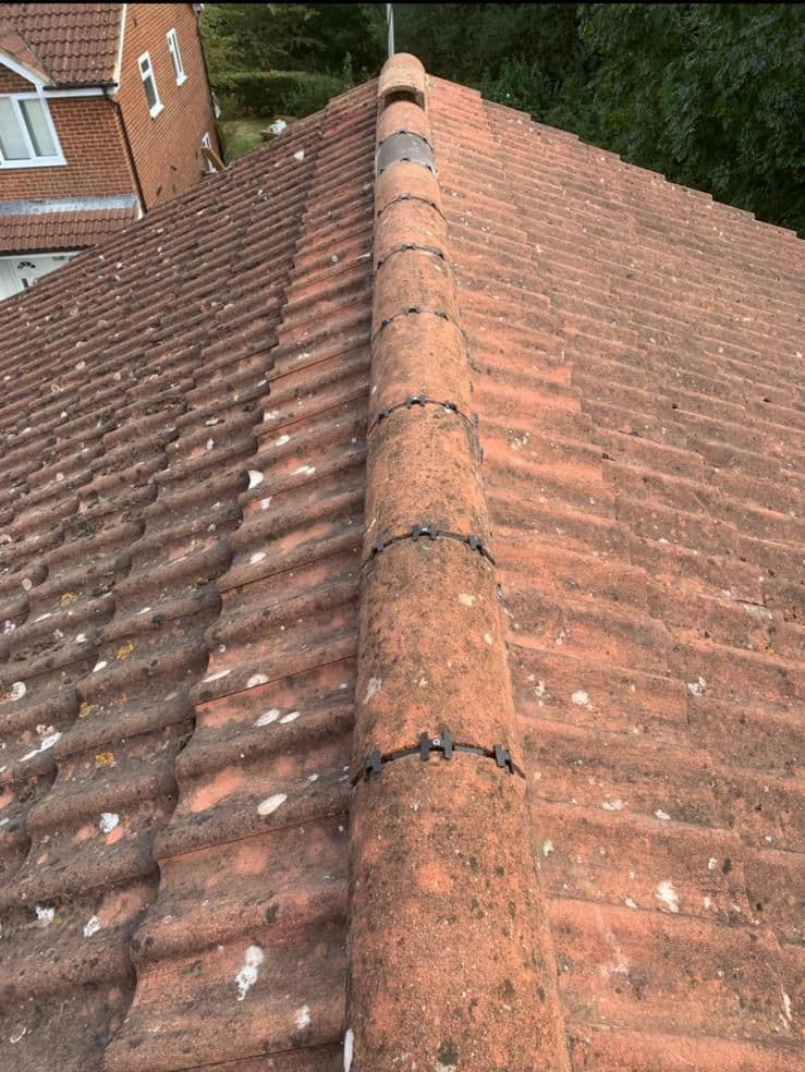 Ridge tiles bedded and pointed along a roof ridge