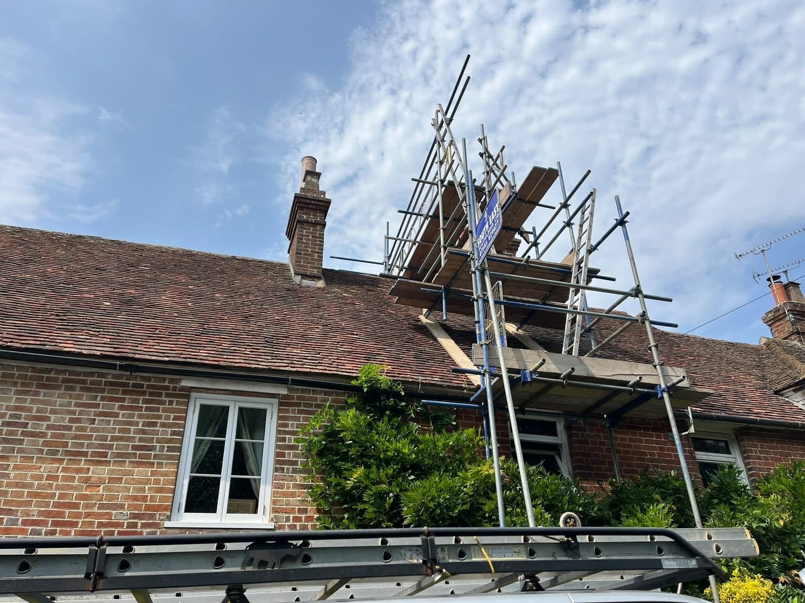 Scaffold up over a clay tiled cottage roof
